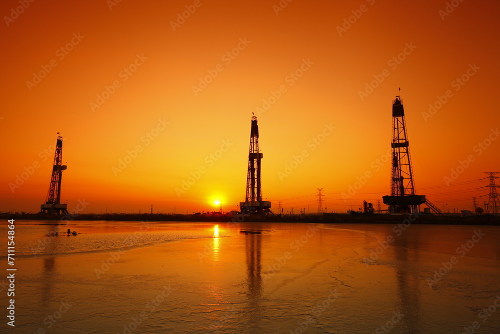 Fototapeta premium Sunset of oil drilling rig in the sea