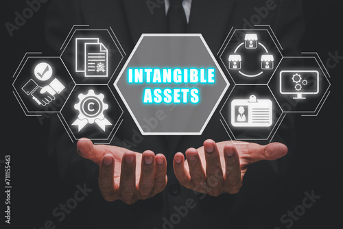 Intangible asset concept, Businessman hands holding intangible asset icon on virtual screen.