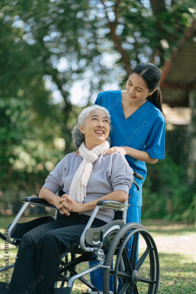 Smiling physiotherapist taking care of the happy senior patient in wheelchair, outdoor. Smiling physiotherapist taking care of the happy senior patient in wheelchair, outdoor.