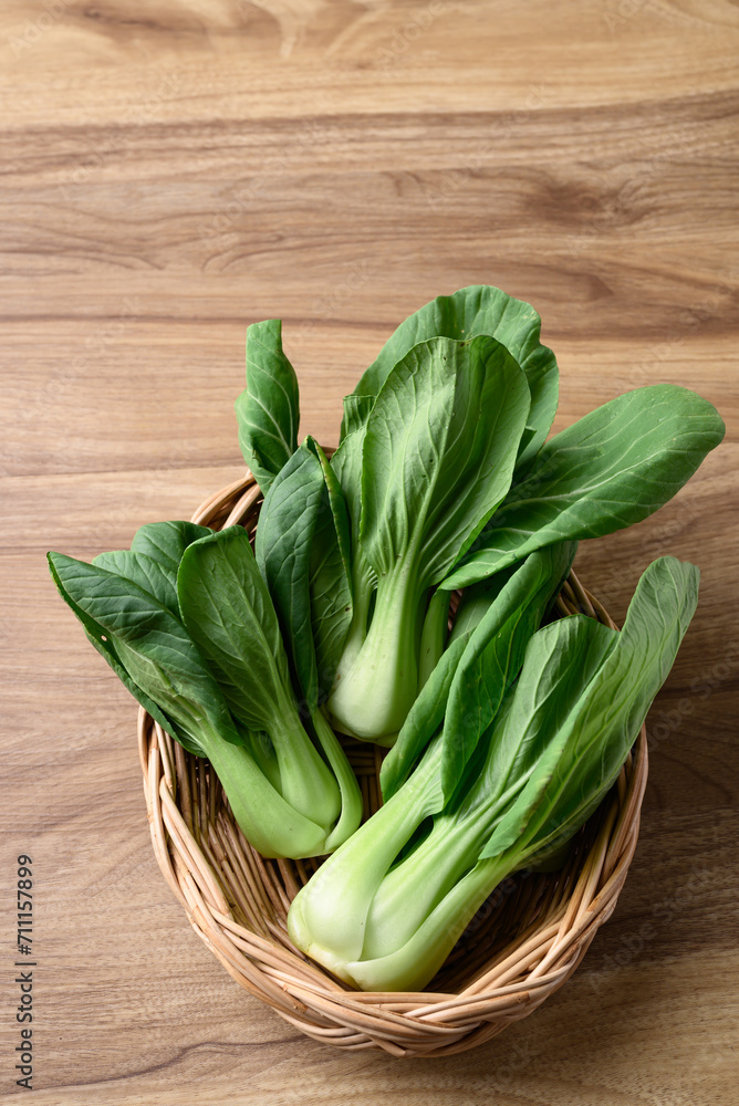 Bok choy or Pak choi (Chinese cabbage) in basket on wooden table, Organic vegetables Bok choy or Pak choi (Chinese cabbage) in basket on wooden table, Organic vegetables