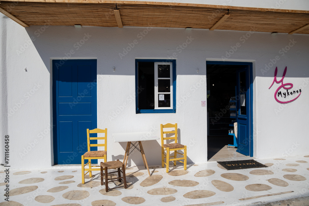 Streetview of Mykonos town with white street and blue door, Greece