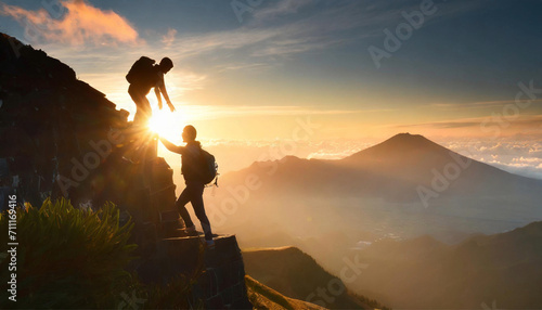 A man climbs a rocky mountain and is helped by his friend photo