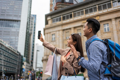 Asian young man and woman shopping goods outdoors in department store.  photo