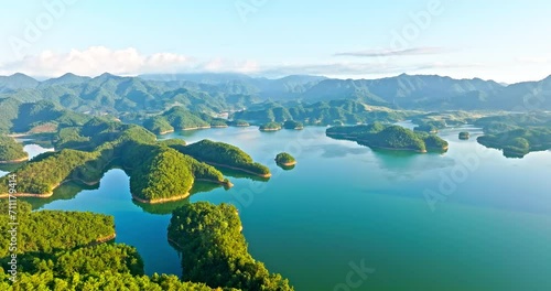 Aerial video of green forest and island with mountains natural landscape in Hangzhou. Beautiful mountain and lake landscape in the morning. Drone shooting forward. photo