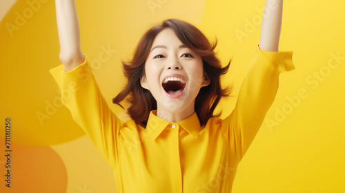 黄色の中ガッツポーズで喜ぶ若い女性 woman fist pump in yellow photo