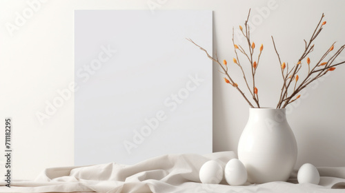 A simple and elegant mockup featuring a white vase with pussy willow branches beside a blank canvas, set on a draped linen fabric.