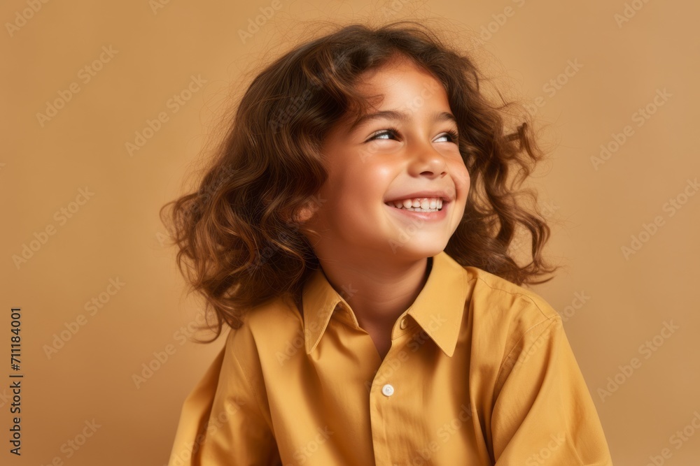 Portrait of a cute little girl in a yellow shirt on a brown background Portrait of a cute little girl in a yellow shirt on a brown background