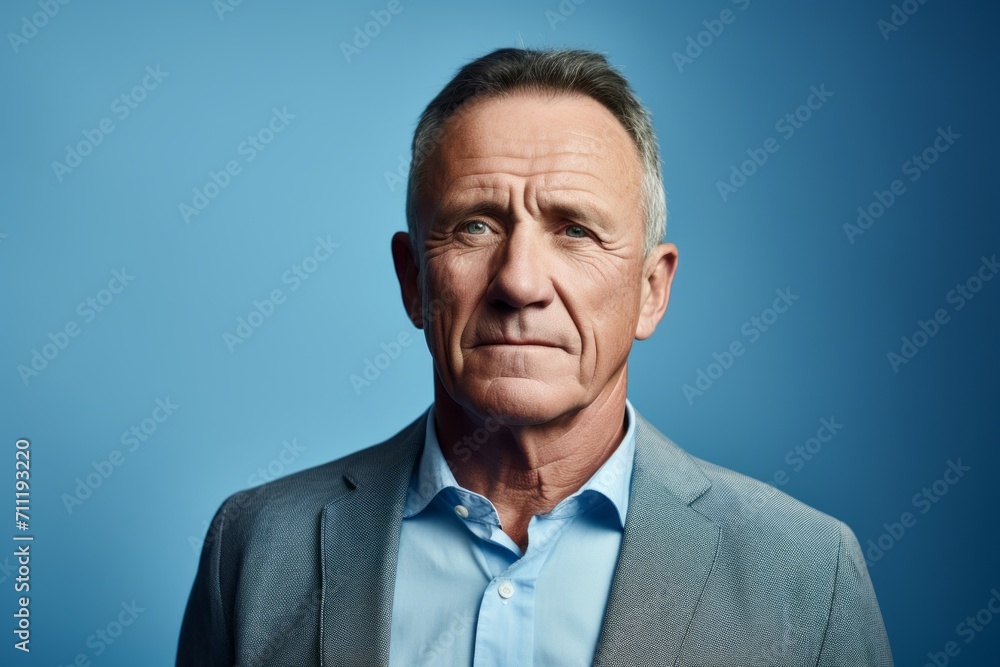 Portrait of a confident senior man looking at camera over blue background. Portrait of a confident senior man looking at camera over blue background.
