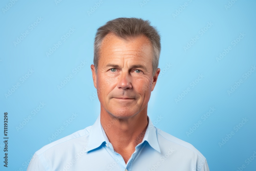 Portrait of senior man with grey hair and blue shirt on blue background Portrait of senior man with grey hair and blue shirt on blue background