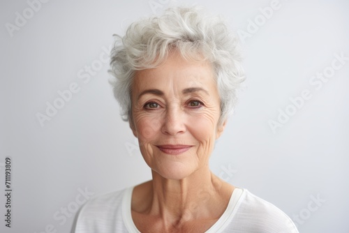 Portrait of a smiling senior woman with grey hair looking at camera