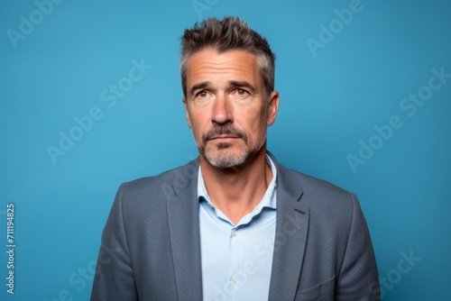 Handsome mature man with mustache making doubts gesture on blue background