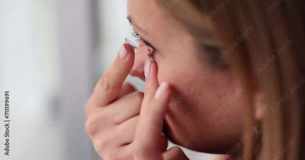 Lady with vision problems puts contact lenses onto eyeball Lady with vision problems puts contact lenses onto eyeball