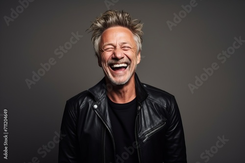 Portrait of a laughing middle aged man in a leather jacket.