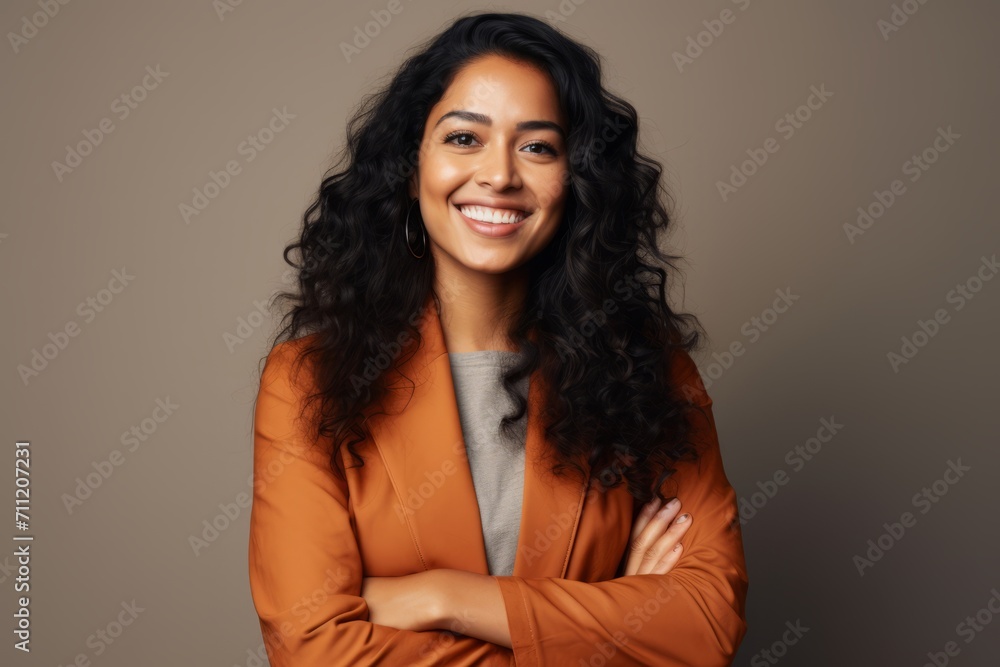 Portrait of a happy businesswoman standing with arms crossed against grey background Portrait of a happy businesswoman standing with arms crossed against grey background
