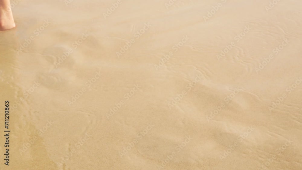 low angle view to barefeet moving on white sand beach with some wave from sea hitting the beach, summer relax vacation holiday natural background in 4k. low angle view to barefeet moving on white sand beach with some wave from sea hitting the beach, summer relax vacation holiday natural background in 4k.