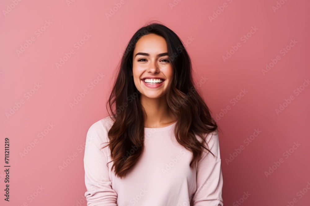 Portrait of a beautiful young woman smiling on a pink background. Portrait of a beautiful young woman smiling on a pink background.