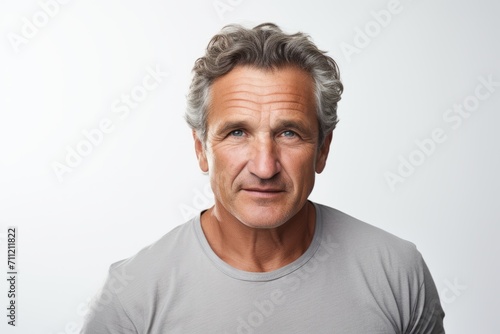 Senior man with grey hair and grey t-shirt. Studio shot.
