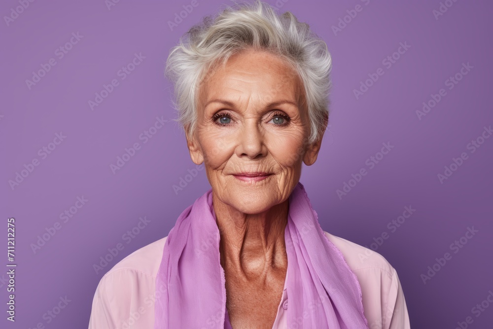 Portrait of a happy senior woman with pink scarf against purple background Portrait of a happy senior woman with pink scarf against purple background