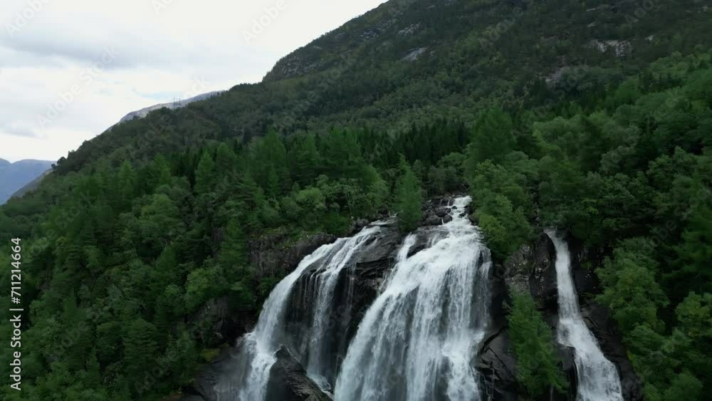 Drone flies away from a waterfall and shows the untamed wilderness of Norway. Drone flies away from a waterfall and shows the untamed wilderness of Norway.