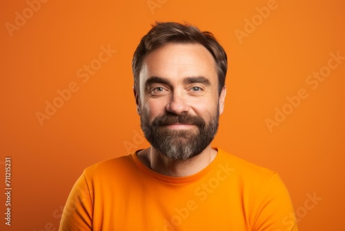 Portrait of handsome man with beard and mustache on orange background.