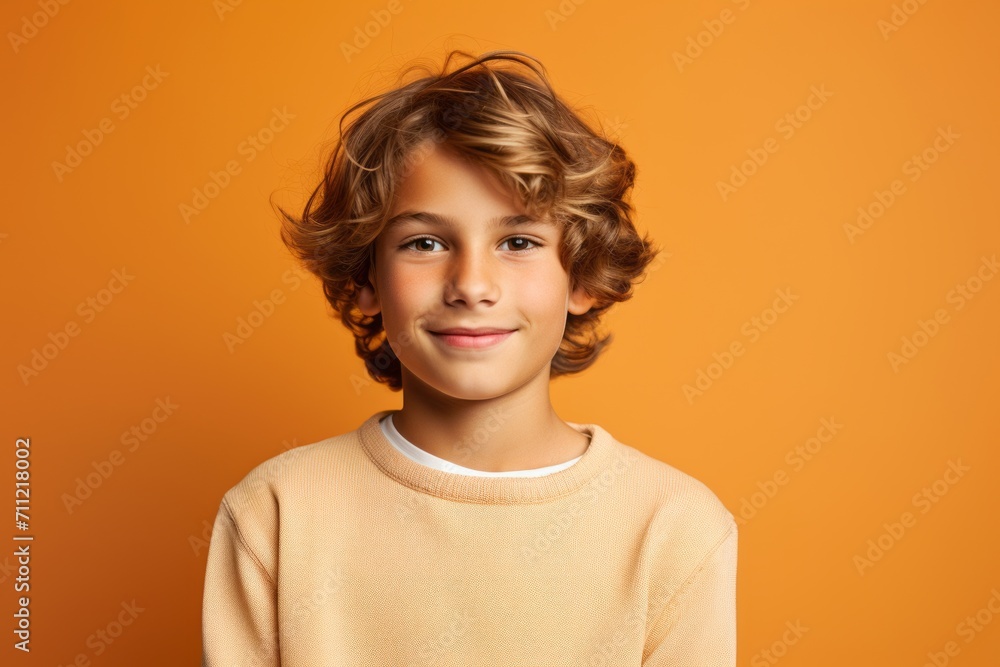 Portrait of a cute little boy with curly hair on orange background Portrait of a cute little boy with curly hair on orange background