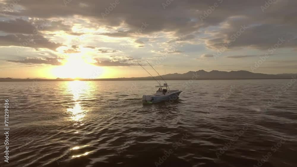 Aerial: Drone Panning Shot Of Motorboat Moving On Waves In Ocean Under Cloudy Sky During Sunset - Magdalena Bay, Mexico Aerial: Drone Panning Shot Of Motorboat Moving On Waves In Ocean Under Cloudy Sky During Sunset - Magdalena Bay, Mexico