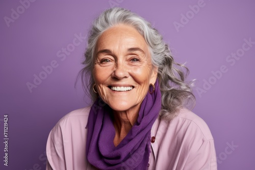 Portrait of smiling senior woman with long grey hair and purple scarf