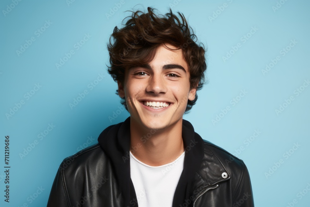 Portrait of a smiling young man in a leather jacket on a blue background Portrait of a smiling young man in a leather jacket on a blue background