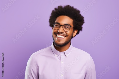 Cheerful african american man in eyeglasses looking at camera, isolated on violet background
