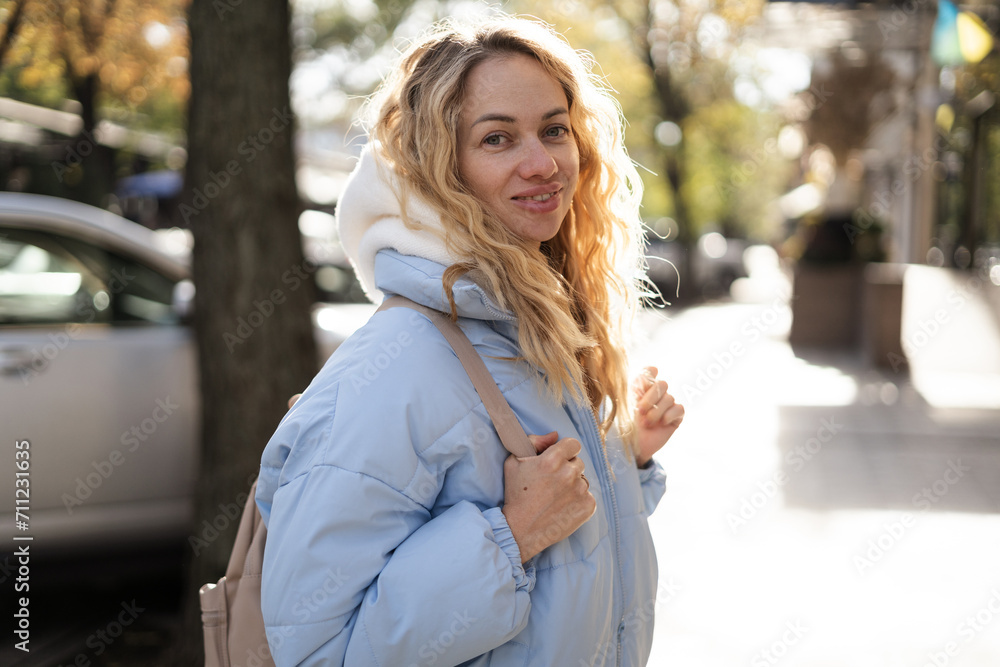 Blonde cute woman tourist walking on the street, spring fashion style, travel to Europe Blonde cute woman tourist walking on the street, spring fashion style, travel to Europe