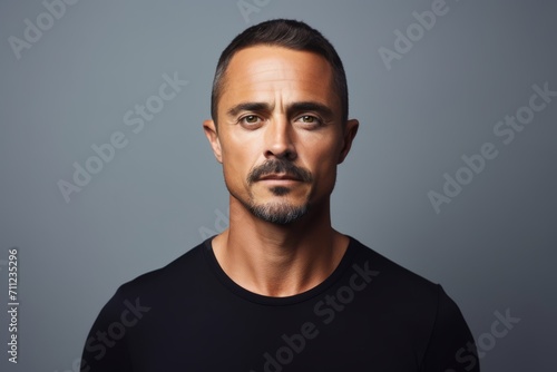 Portrait of a handsome man in black t-shirt over grey background.