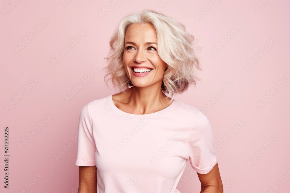 Portrait of a happy senior woman looking at camera against pink background Portrait of a happy senior woman looking at camera against pink background