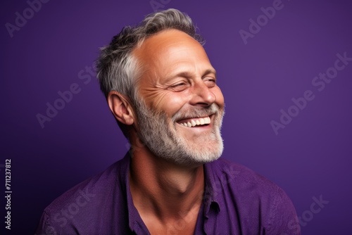 Portrait of a happy senior man with grey hair and beard laughing. © Inigo