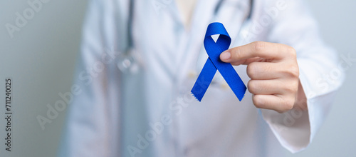 March Colorectal Cancer Awareness month, doctor with dark Blue Ribbon for supporting people living and illness. Healthcare, hope and World cancer day concept