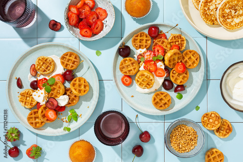 Fototapeta Naklejka Na Ścianę i Meble -  Sweet breakfast with mini waffles and fresh berries, strawberries and cherries. Top view.