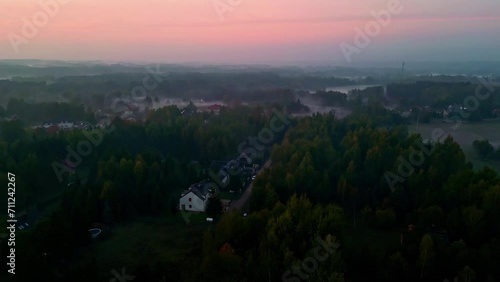 Aerial view of colorful sky illuminated by sunset over large villa's surrended by forest. photo