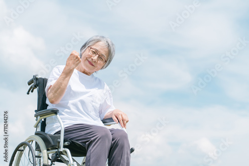 青空と車椅子に座る高齢者・シニア女性（介護・車椅子・おばあちゃん・デイサービス） 