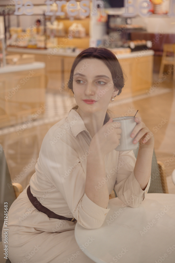 Young Caucasian Female portrait in coffee shop holding a cup of coffee
