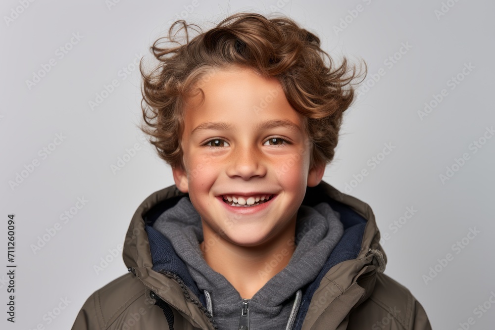 Portrait of a smiling little boy in a warm jacket on a gray background Portrait of a smiling little boy in a warm jacket on a gray background
