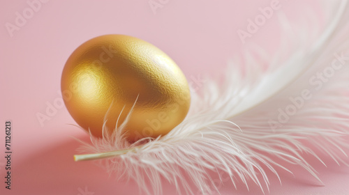 A golden egg rests delicately on a soft white feather against a pastel pink background, symbolizing luxury or Easter celebration