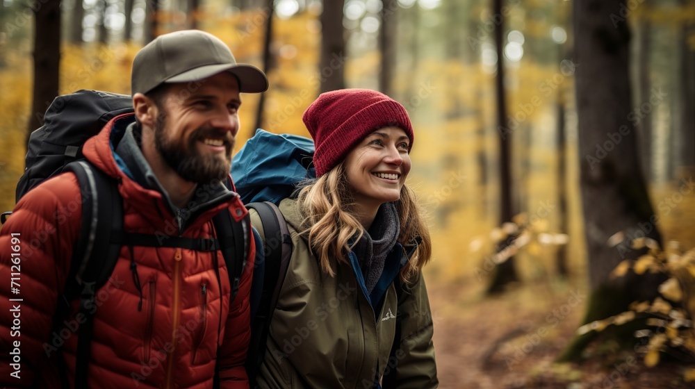 Happy couple hiking in autumn forest with colorful foliage and backpacks
