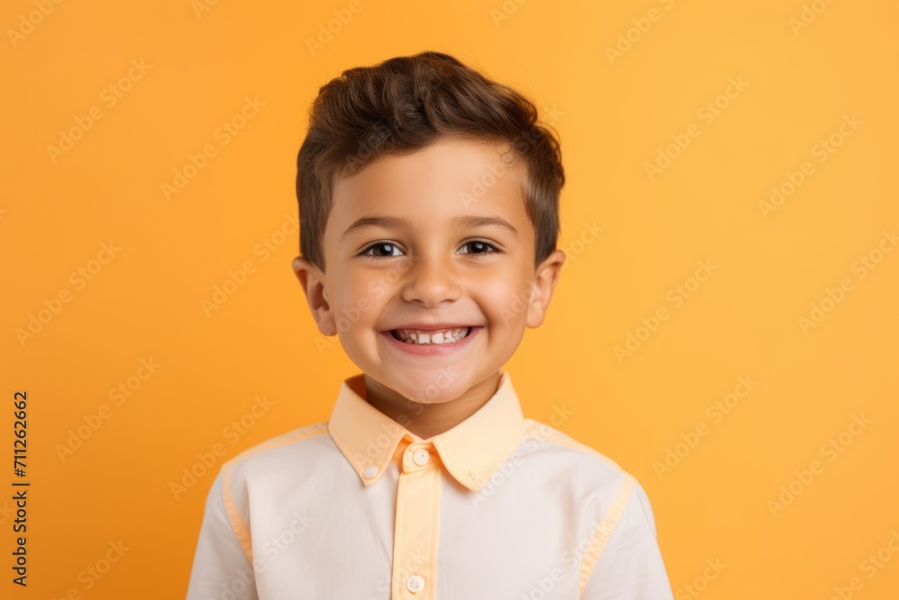 smiling little boy in shirt looking at camera isolated on orange background smiling little boy in shirt looking at camera isolated on orange background
