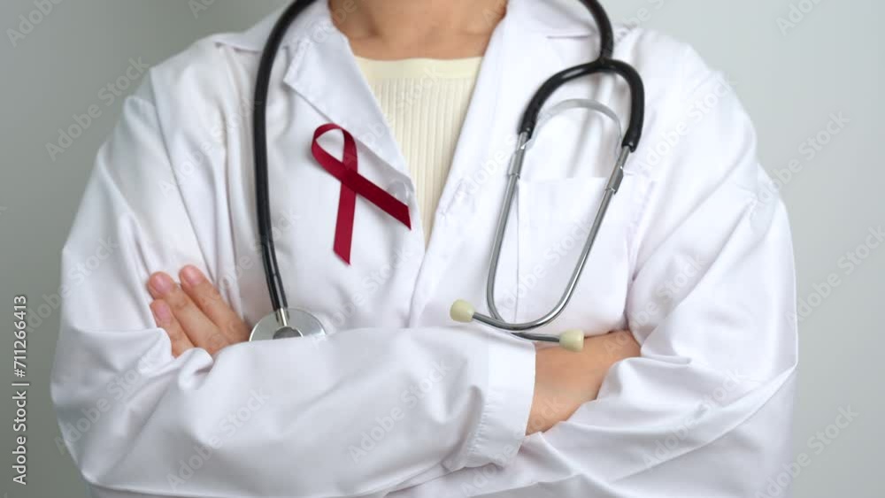 Doctor with Burgundy Red Ribbon for March multiple myeloma Cancer and December World Aids Day Awareness month. Healthcare and world cancer day concept Doctor with Burgundy Red Ribbon for March multiple myeloma Cancer and December World Aids Day Awareness month. Healthcare and world cancer day concept