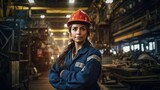 Portrait of female industry maintenance engineer in uniform and hard hat at factory station