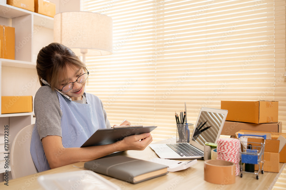 Sell products online, Young woman Multitasking: take orders from customers who call by phone, Young woman who has a lot of work and is very busy with work, Freelance working. Sell products online, Young woman Multitasking: take orders from customers who call by phone, Young woman who has a lot of work and is very busy with work, Freelance working.