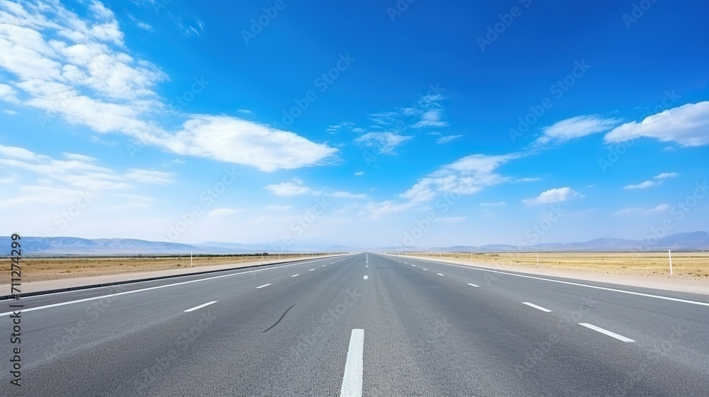 highway in the grassland background of blue sky and bright clouds, long road stretches into the distance. empty street on a beautiful sunny day