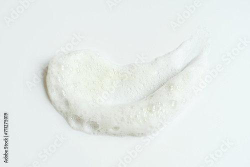 Smear of facial cleansing foam on white background close-up.