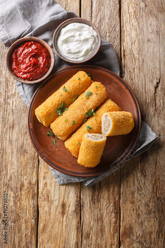 Krokiety Polish style croquettes filled with beef closeup on the plate on the wooden table. Vertical top view from above