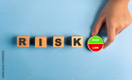 Hand holding a circular stick with the words high and low in risk management.