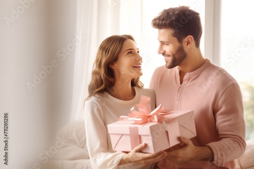 Couple comprising female and male partners holds gift in hands. Man orchestrated delightful surprise for beloved girlfriend presenting substantial gift
